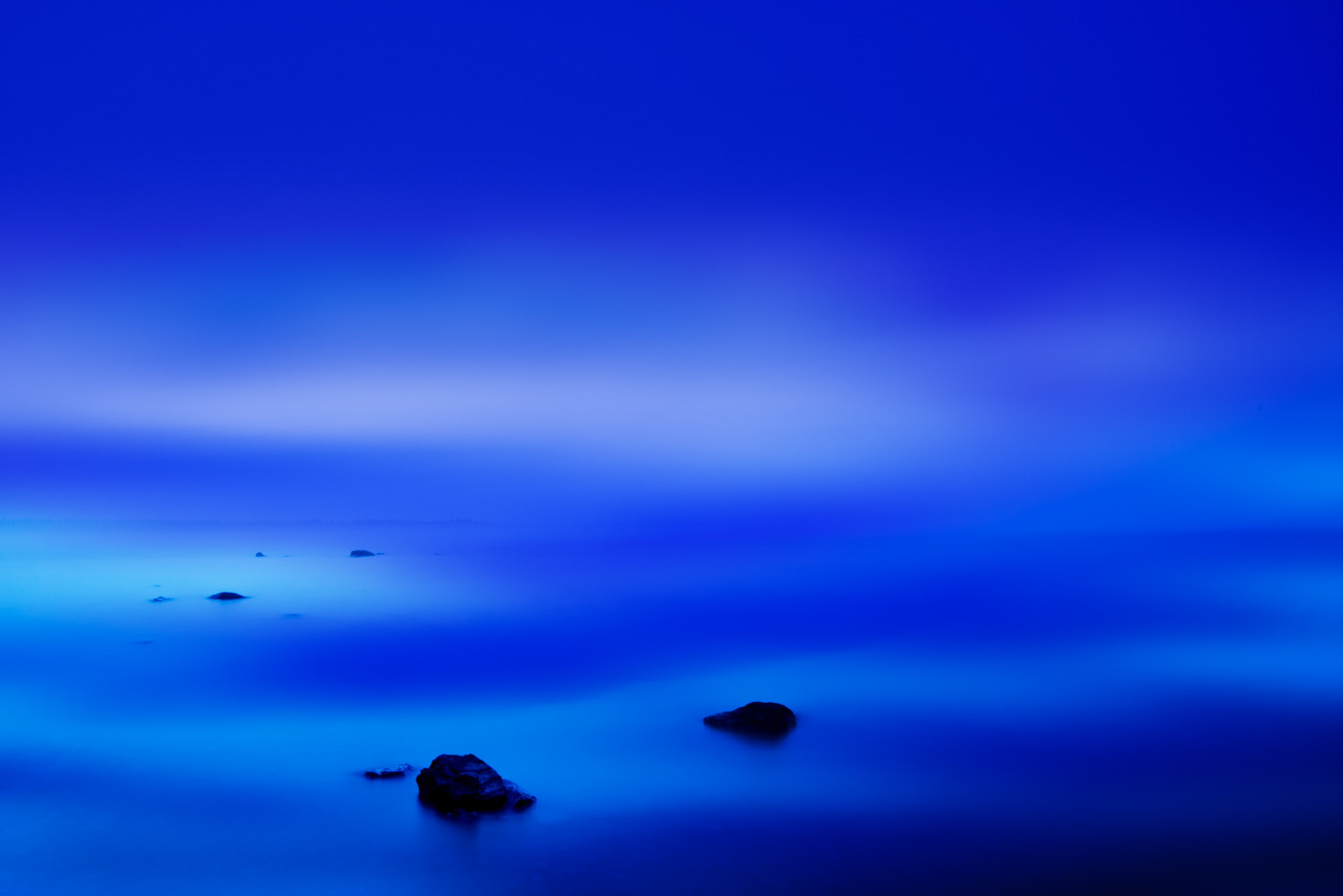 Jeux de lumière à l'aube sur le lac Yellowstone. Photographie en noir et blanc. Photographie par Amar Guillen, artiste photographe.