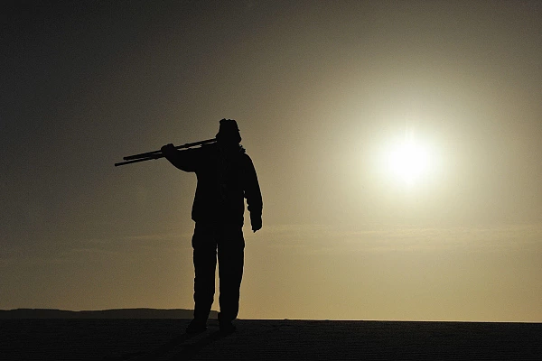 3 Tips to Develop Your Photographic Intentionality Amar Guillen, photographer walking in the desert under the sun at sunset.
