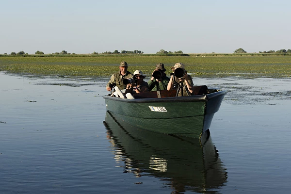 Compte rendus des stages photo animalière, sous-marine et paysage Un groupe de stagiaires prenant des photos depuis une barque pendant un stage dans le delta du Danube en Roumanie.